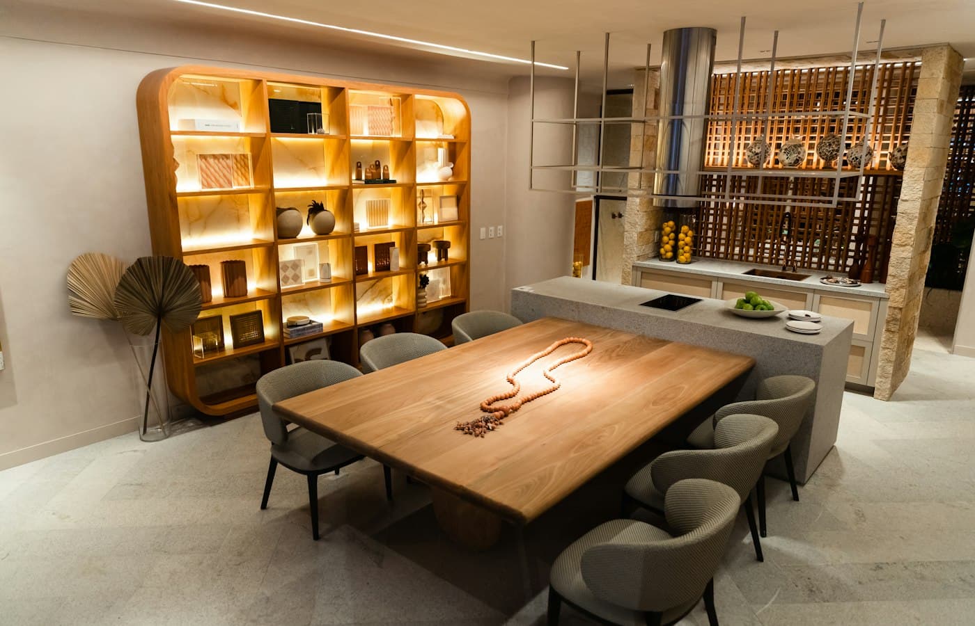Une grande table en bois entourée de chaises dans une salle lumineuse