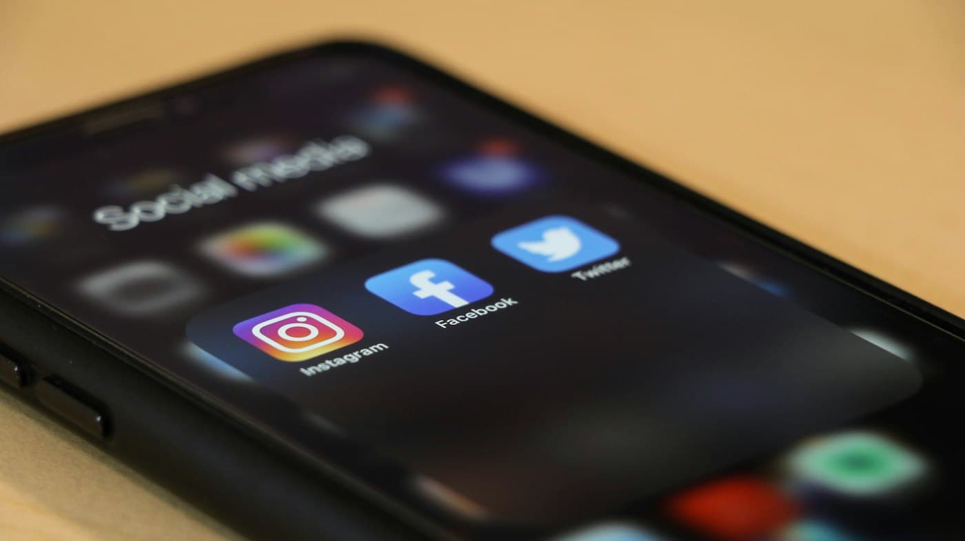 Un smartphone affichant les icônes des réseaux sociaux Instagram, Facebook et Twitter