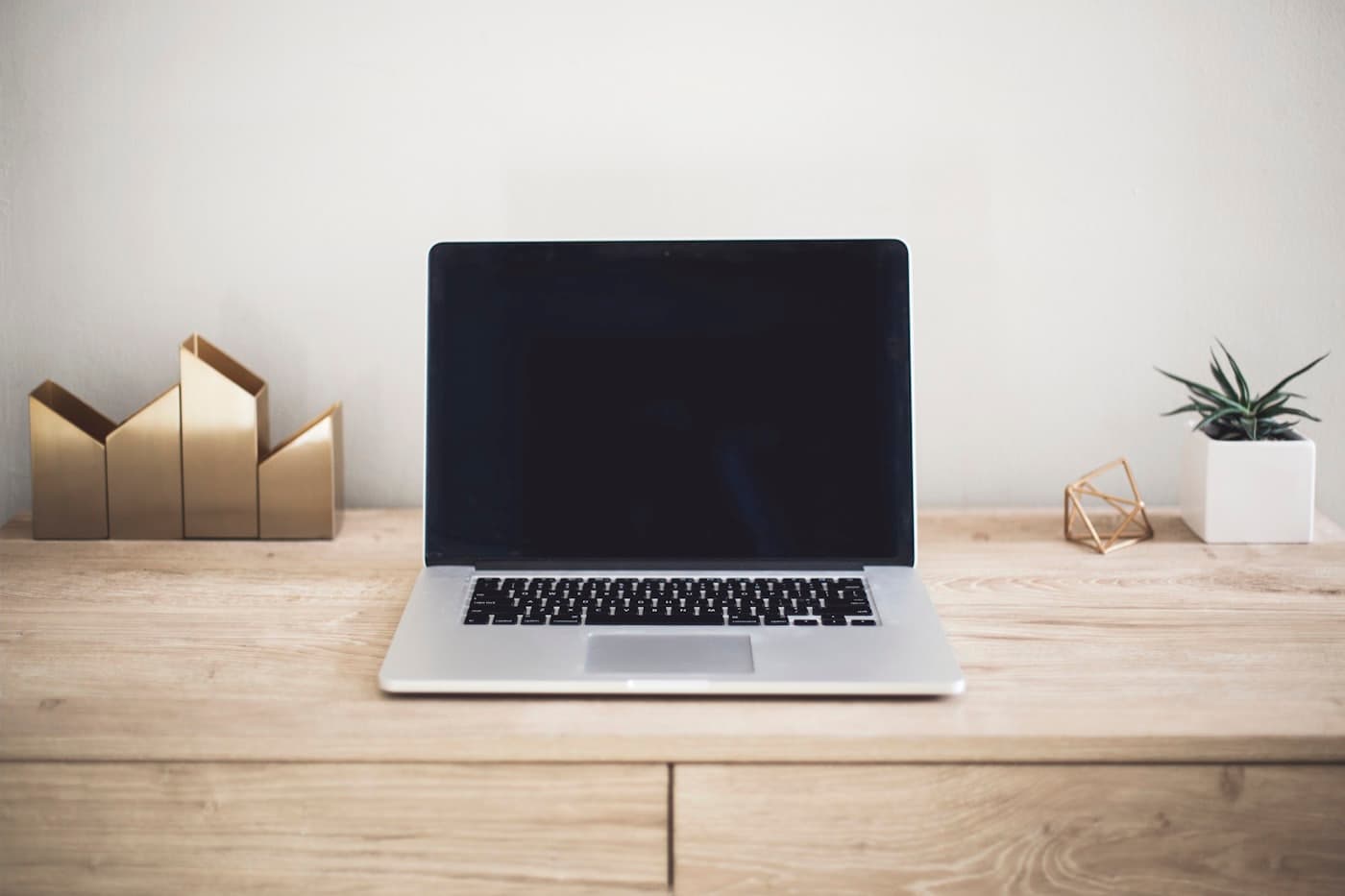 Un ordinateur portable posé sur un bureau en bois, prêt à gérer une boutique en ligne