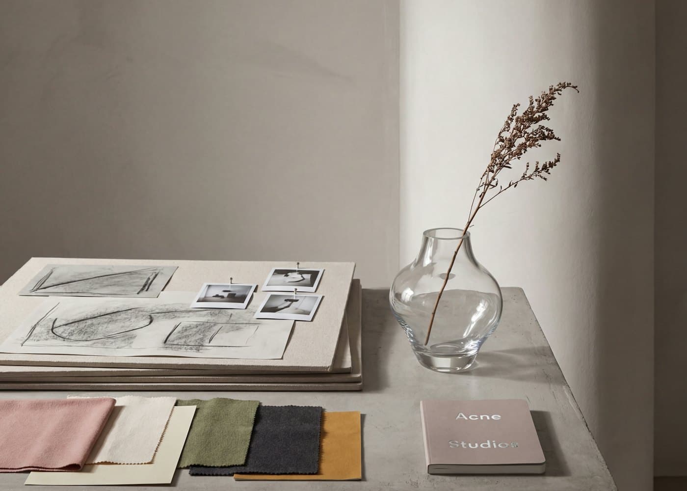 Des échantillons de tissus et des croquis posés sur une table de travail