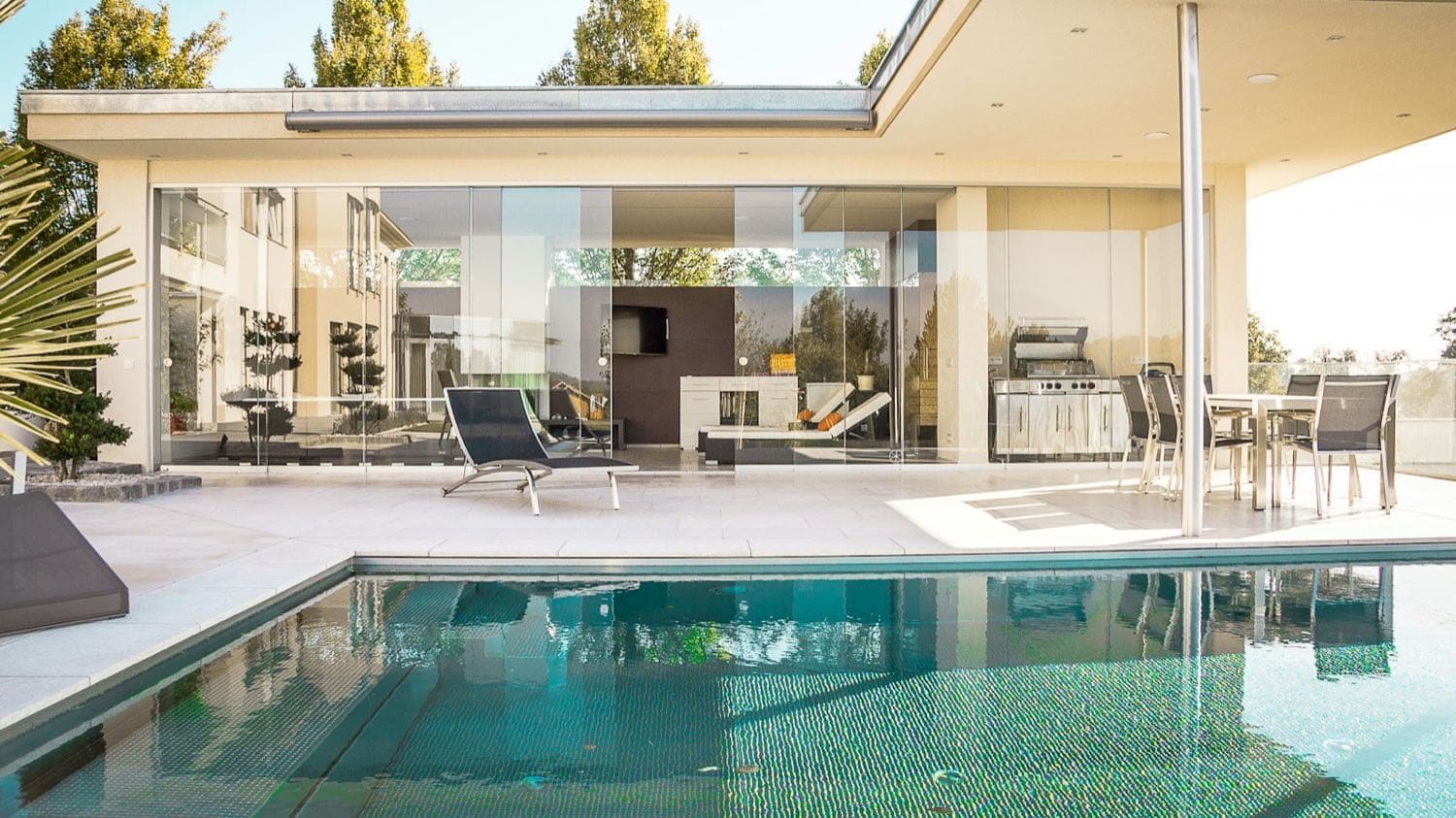 Une maison contemporaine aux grandes baies vitrées, au bord d'une piscine